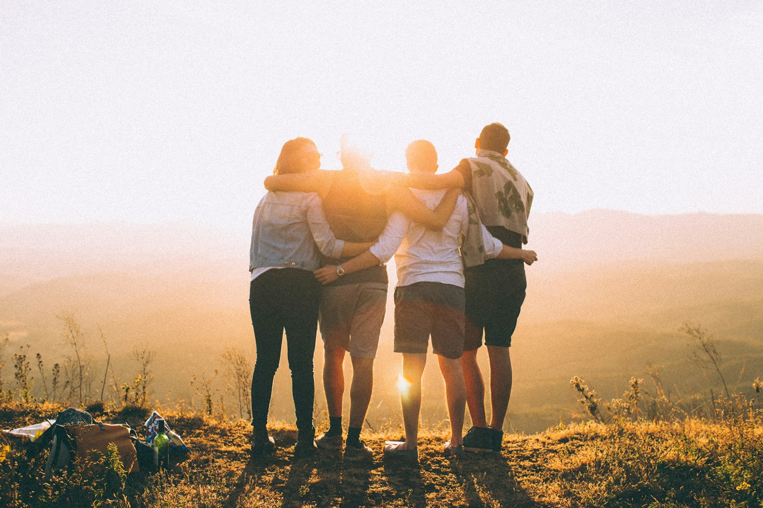 A group standing together in warm evening light, illustrating connection and support
